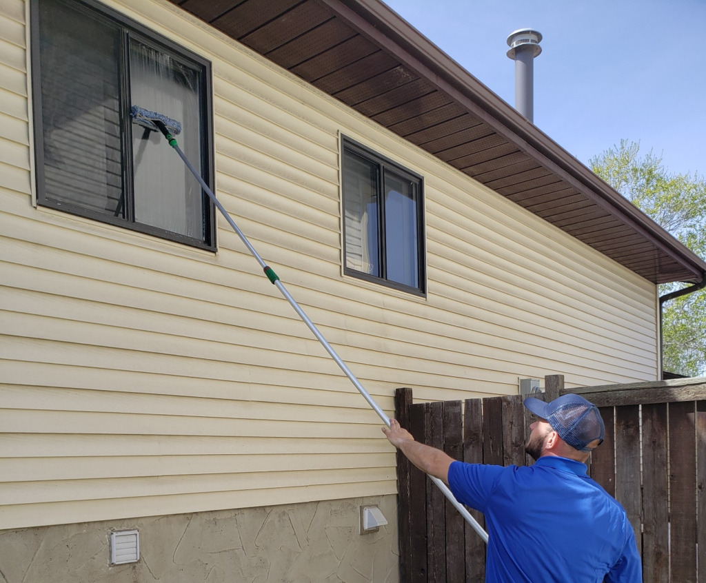 A professional home cleaner cleaning a window