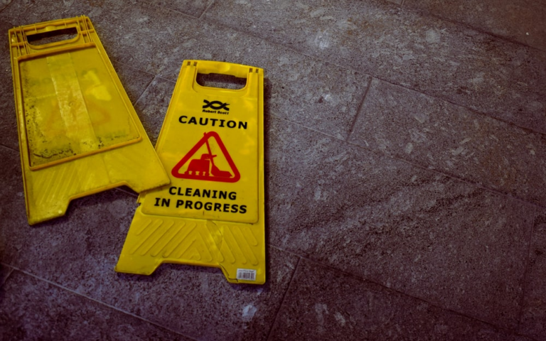 Two floor signs reading “Caution: Cleaning in Progress”