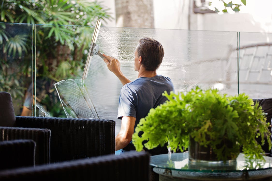 A professional cleaner cleaning an outdoor window