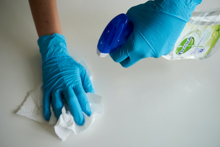 A professional cleaner sanitizing a surface with Dettol