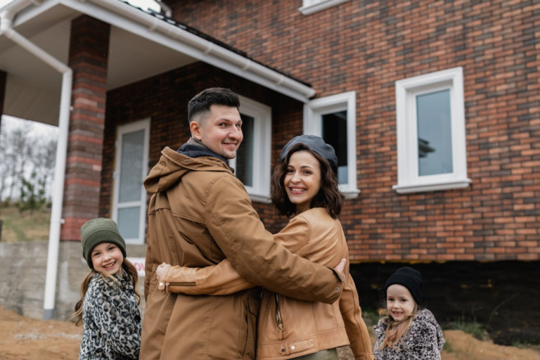 family in front of their new brick home